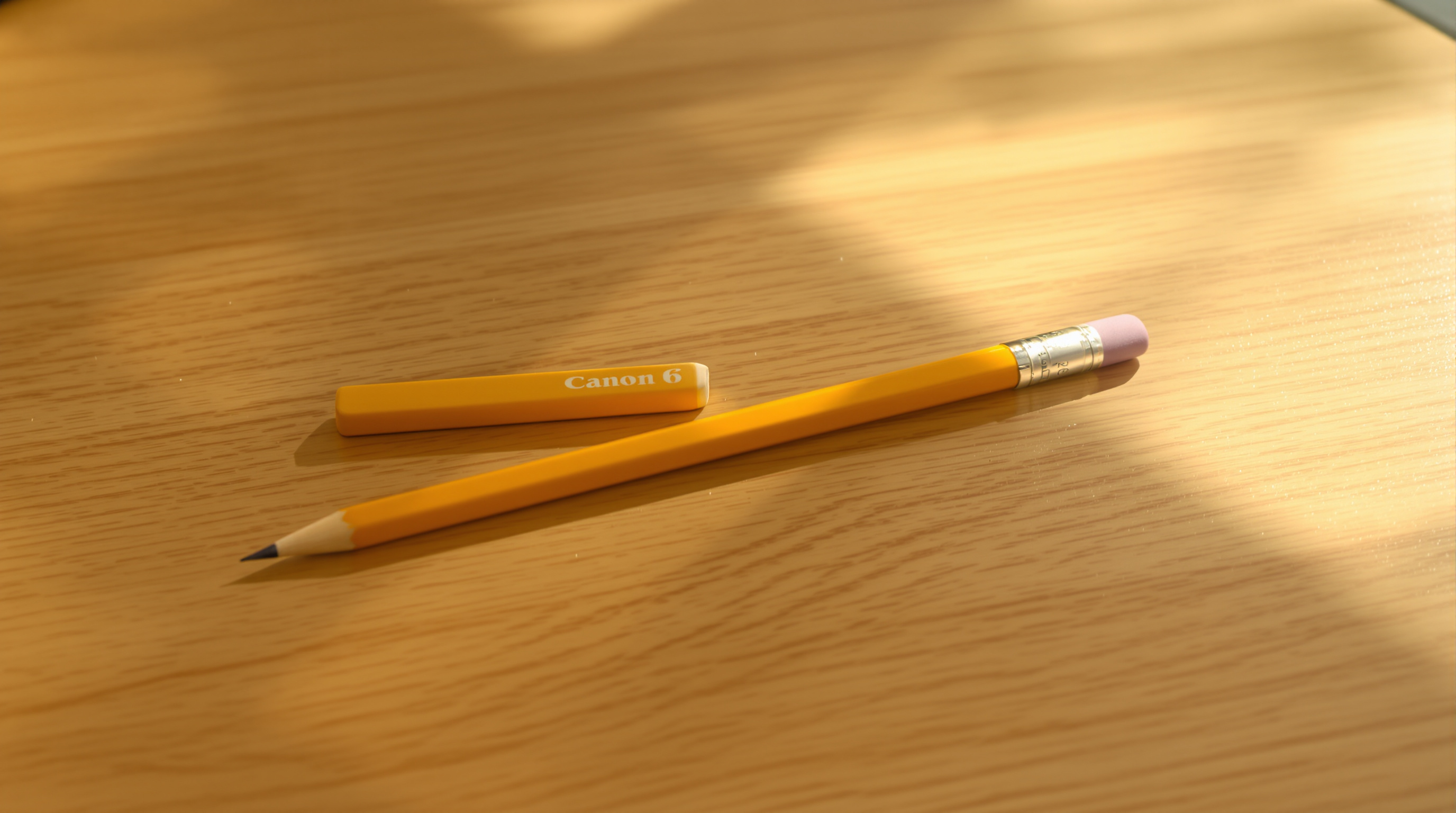 A yellow pencil and an eraser lying on a sunlit wooden school desk